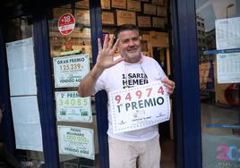 Oriol Villar, con camiseta blanca, celebra el décimo de la Lotería del Niño vendido en su administración.