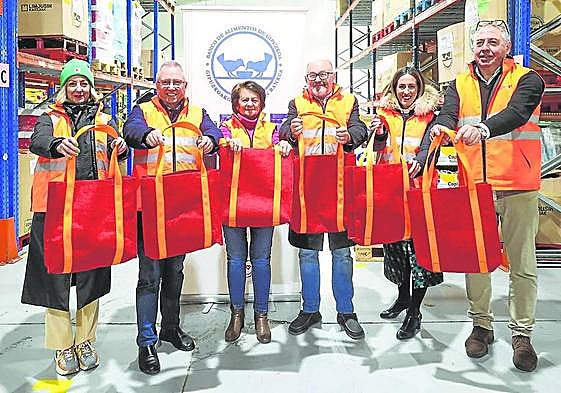 Representantes de la Diputación Foral, el Zinemaldia, el Banco de Alimentos y Emaús posan con las bolsas.
