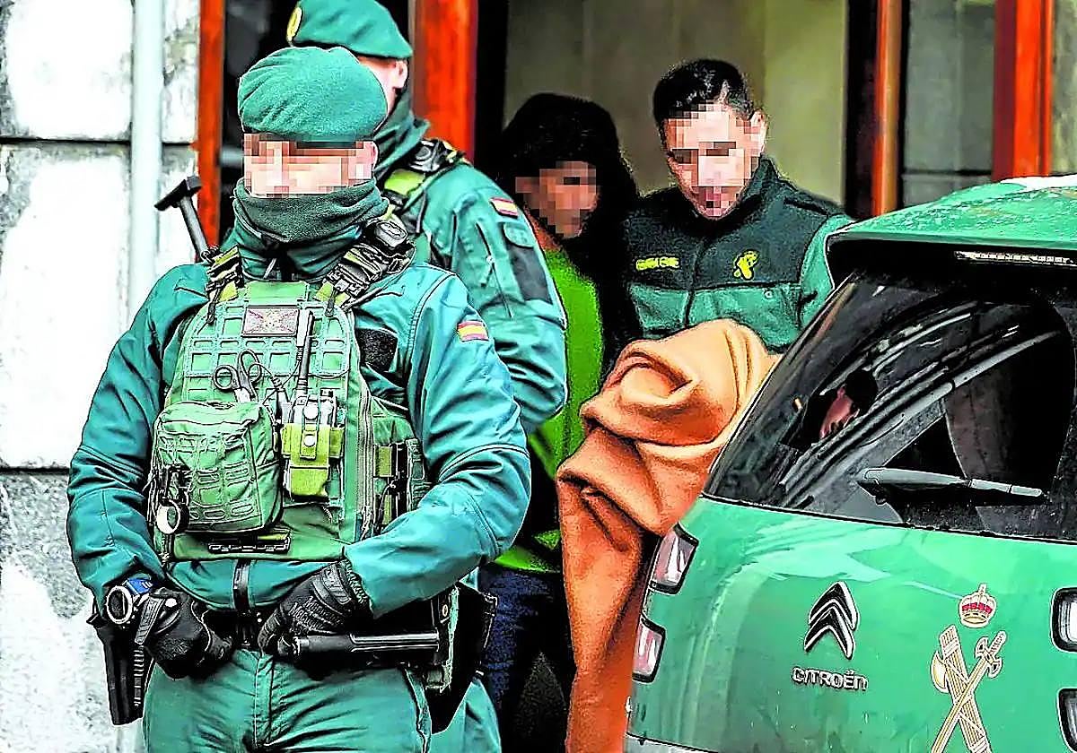 Agentes de la Guardia Civil con el detenido este lunes en Romo, tras finalizar el registro de la vivienda.