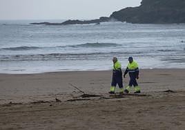 Dos operarios del servicio municipal de Playas de Donostia revisan ayer la orilla de la playa de Zurriola en busca de pélets.