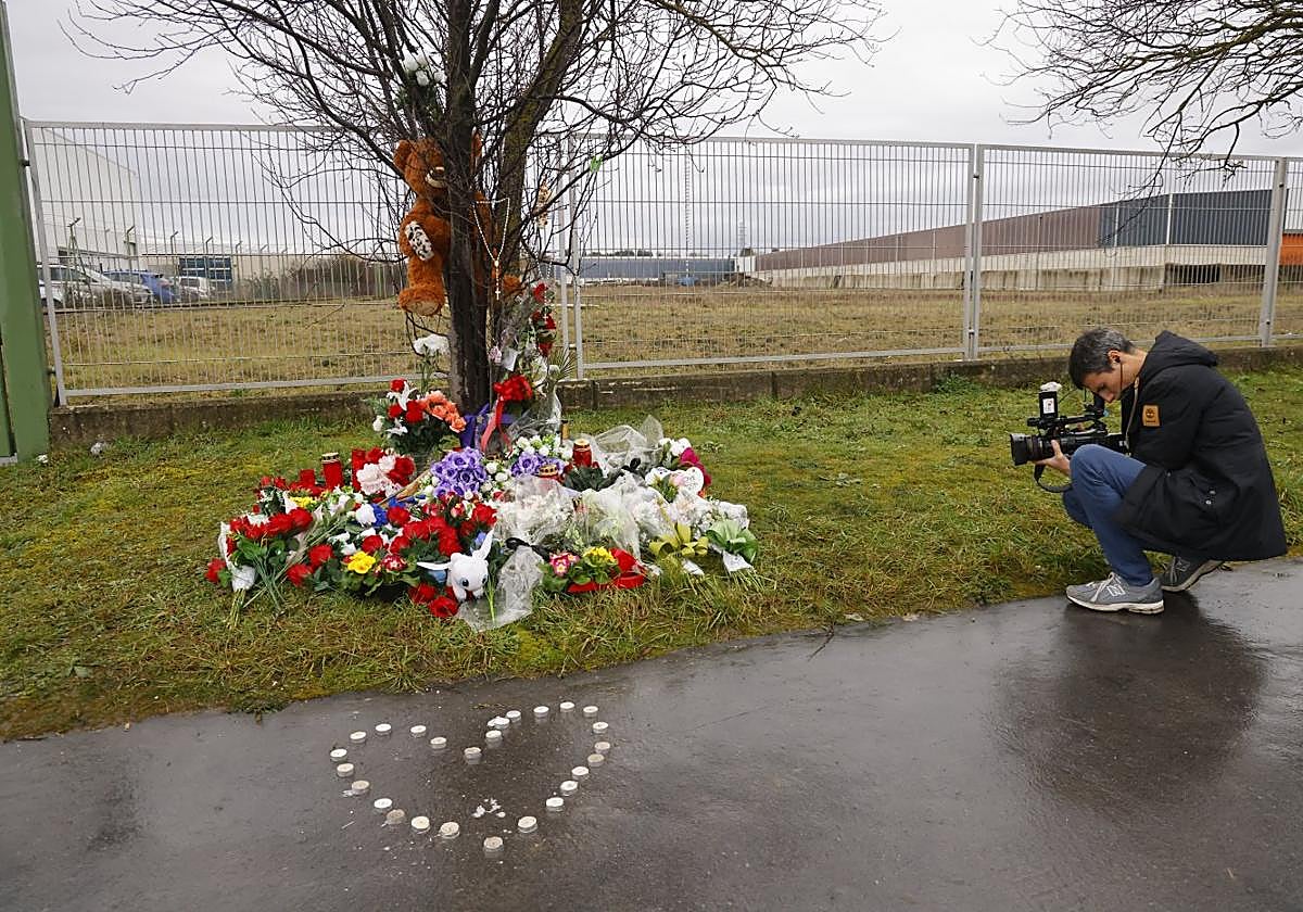 Un cámara graba el pequeño altar improvisado en memoria de Cristian e Izaro en la calle Júndiz.