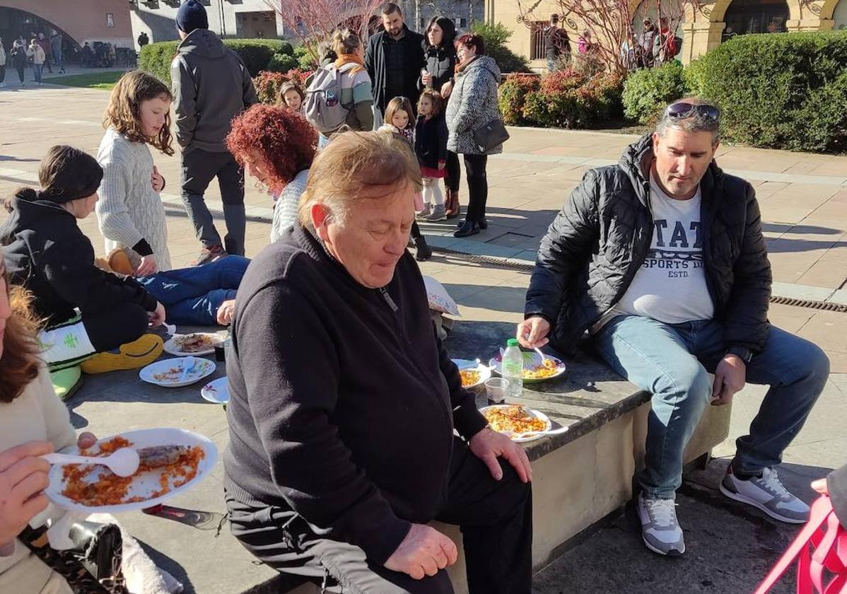 Niños y mayores disfrutando de las populares migas en las inmediaciones de la plaza.