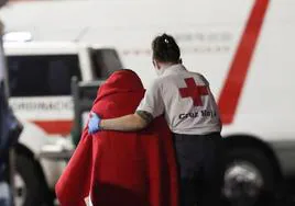 Una voluntaria de Cruz Roja ayuda a una persona extranjera recién llegada.