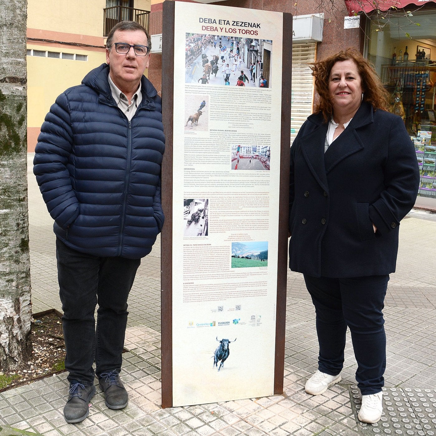 Raimundo Amutxastegi y Alazne Txurruka con el cartel en el recorrido del encierro.