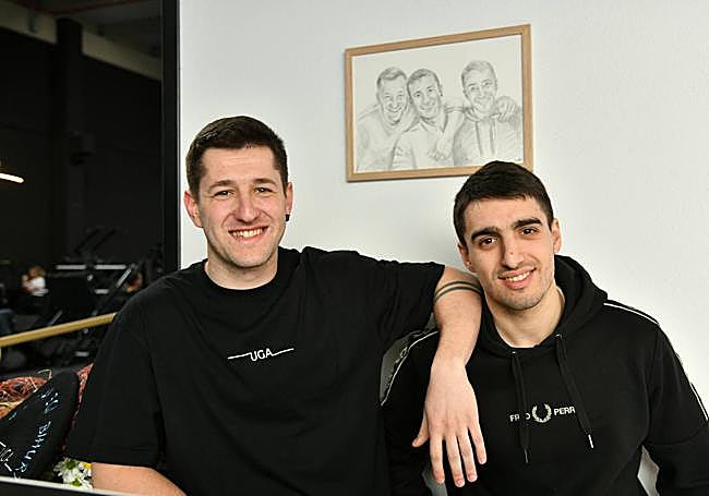 Urtzi e Iñigo posan delante del dibujo en el que está, en medio de los dos, Ugaitz Kerejeta.