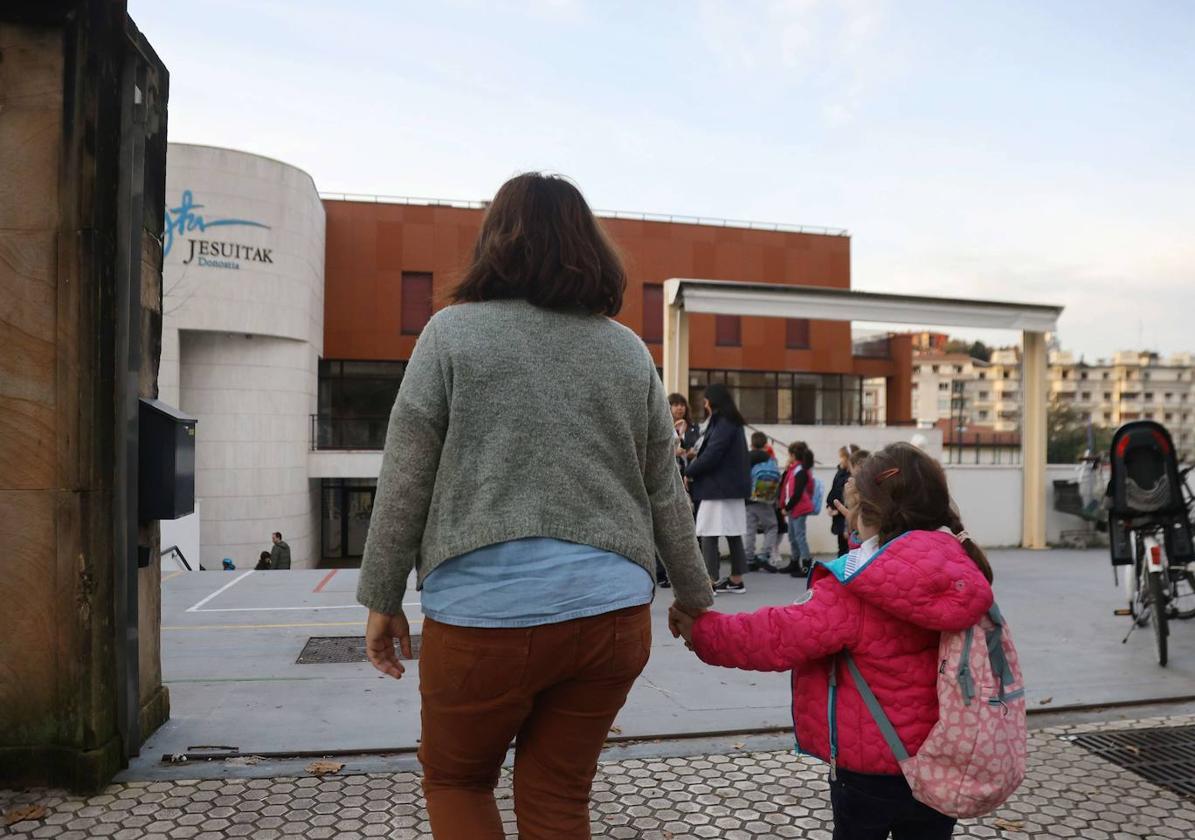 Una madre lleva a su hija al colegio.