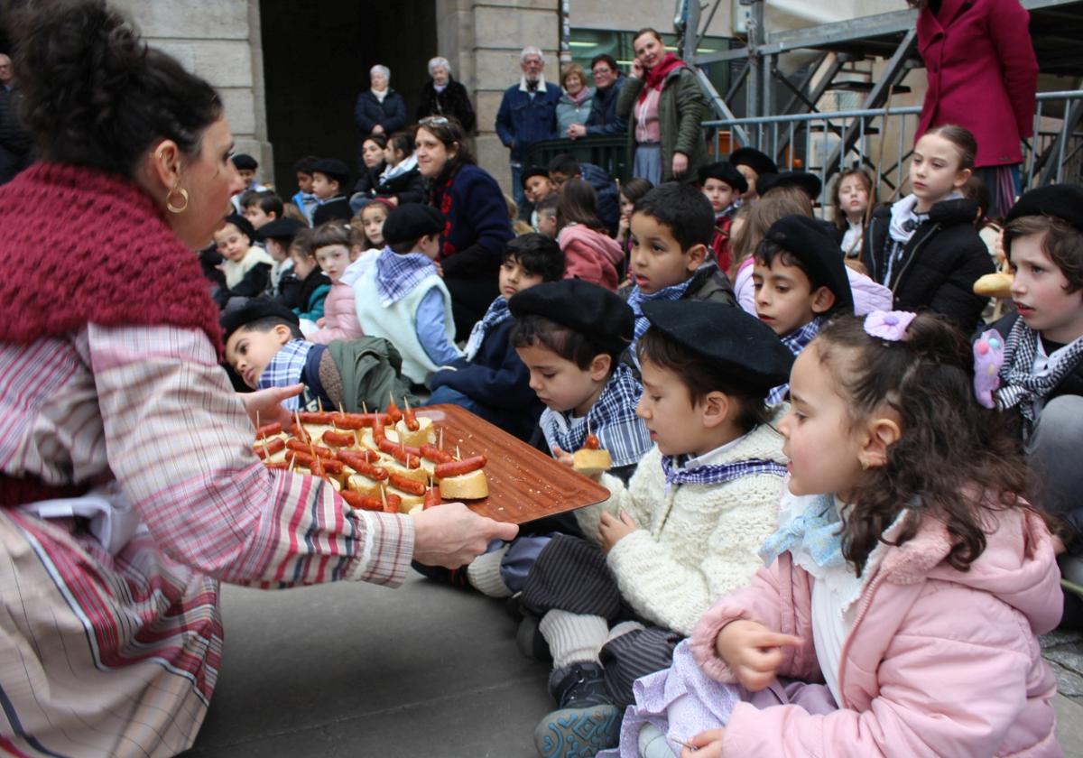 Goizean kalez kale kantuan ibili ostean, bi ikastetxeetako haurrak Fernando Eskoriatza plazan elkartu dira txistorra pintxoak dastatzeko asmoz