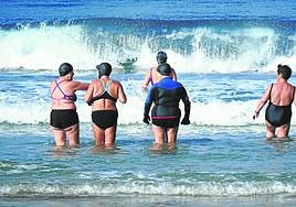 Varias mujeres entran al agua en Año Nuevo para darse un chapuzón en la playa de La Concha.