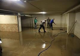 Varios vecinos se afanan con los cepillos para terminar de evacuar todo lo que entró en sus garajes de Amasa-Villabona.