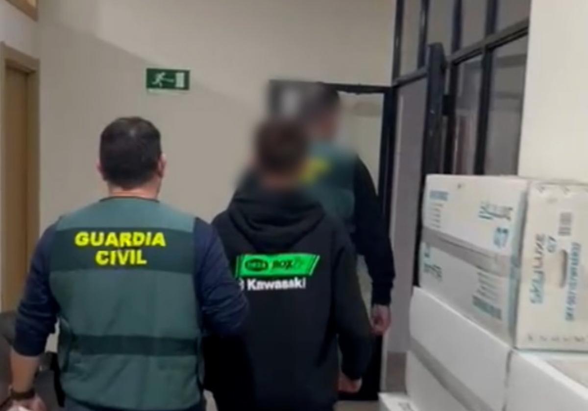 Dos guardias civiles escoltan a uno de los menores arrestados.