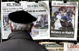 Un ciudadano lee las primeras páginas de los periódicos en un quiosco el 12 de marzo de 2004.