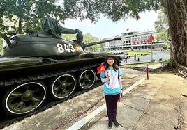 Uns chica vietnamita posa ante el museo de la reunificación de Ho Chi Minh después de «entrevistar» al cronista.