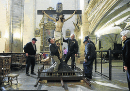 Cuatro voluntarios colocan el sudario de Cristo en un paso que saldrá en la procesión de Viernes Santo en Segura.