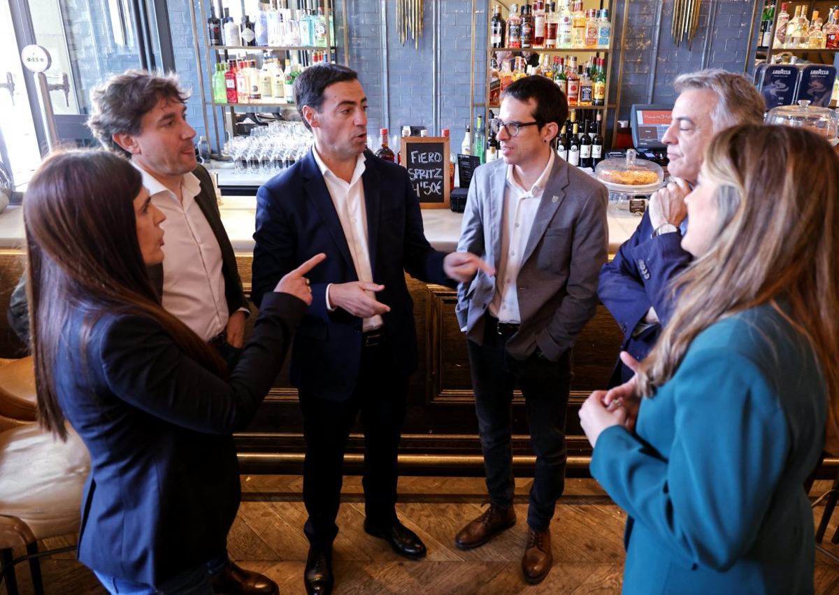 Imagen secundaria 1 - Sesión de fotos. En esta página, los candidatos a lehendakari posan junto al reloj de la plaza de Gipuzkoa, en el bar del hotel Gorka y durante los saludos en los primeros minutos del encuentro.