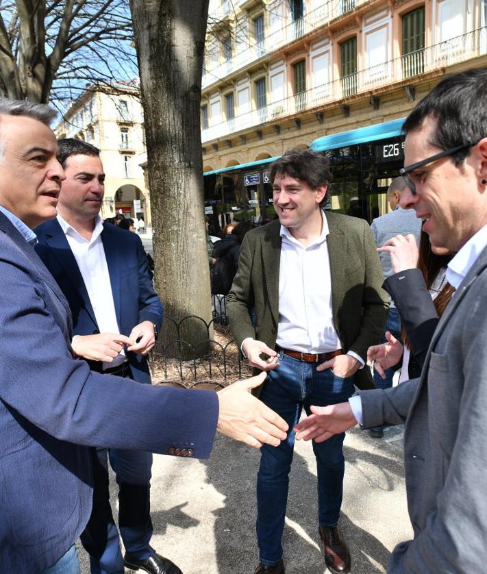 Imagen secundaria 2 - Sesión de fotos. En esta página, los candidatos a lehendakari posan junto al reloj de la plaza de Gipuzkoa, en el bar del hotel Gorka y durante los saludos en los primeros minutos del encuentro.