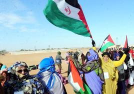 Mujeres saharauis desplazadas ondean la bandera del Sáhara, casi medio siglo de aspiración de un estado propio.