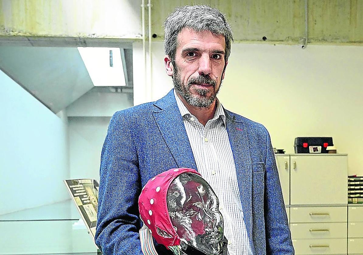 Javier Díaz sujeta un gorro con electrodos para medir las señales del cerebro.