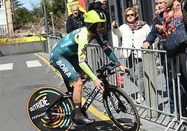 Roglic da la vuelta tras equivocarse en el recorrido mientras una aficionada le señala la dirección correcta.