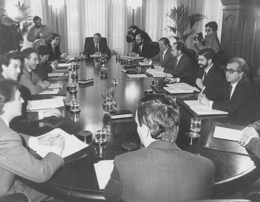 Una reunión del Gobierno Vasco presidida por José Antonio Ardanza en 1987. Posa acompañado por todos los miembros del gabinete sentados en la mesa del consejo de gobierno.