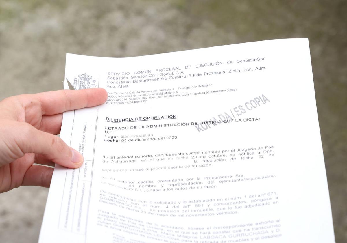 Imagen secundaria 1 - Una camisa, una chaqueta y unos zapatos es todo lo que Julián pudo llevarse (1). El documento de acta procesal (2). La cerradura fue cambiada antes de su desahucio (3).
