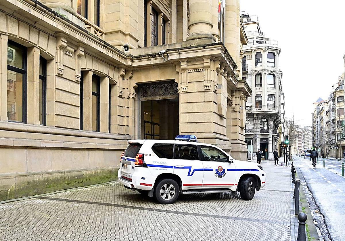 Un coche de la Ertzaintza vigila la entrada a la Audiencia.