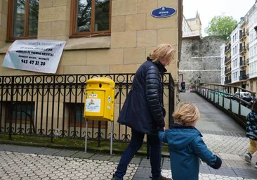 Una mujer se acerca con un niño de la mano a la entrada de la haurreskola de Urbieta Urdaneta, en Donostia.