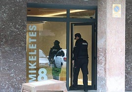 Dos ertzainas acceden al portal del bloque donde ocurrió el crimen.
