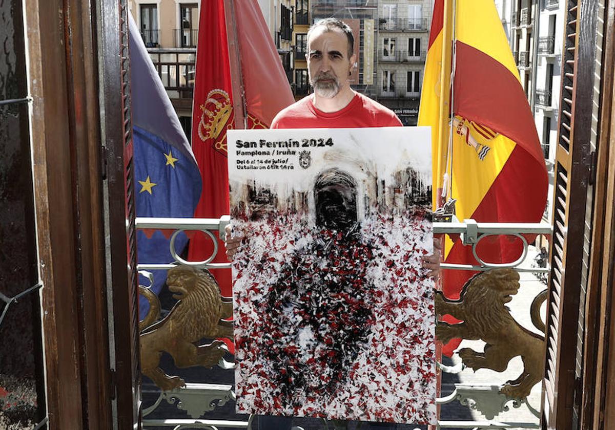 El diseñador guipuzcoano Ángel Blanco posa en el balcón del Ayuntamiento de Pamplona con su obra.