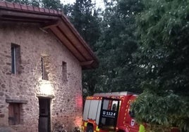 Un camión de los bomberos en la entrada del caserío en el que se ha declarado el incendio.