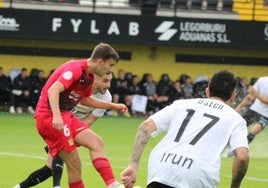 El jugador del Fuenlabrada despeja un balón ante la presión de los jugadores del Real Unión