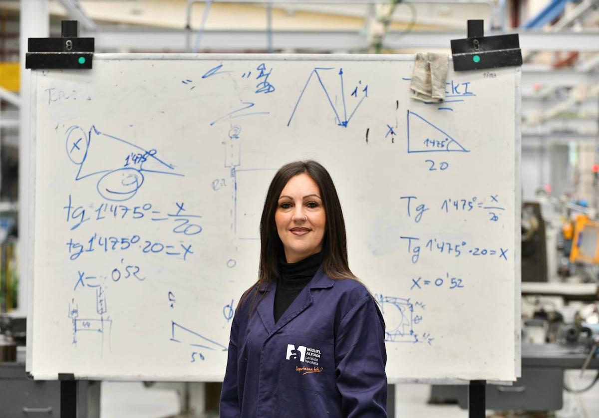 Susana posa delante de una pizarra con las fórmulas matemáticas que aplica después en el aula.