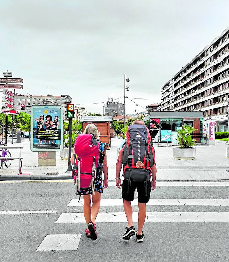 Dos peregrinos caminan por el centro de la ciudad.