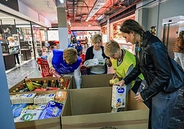 Varias voluntarias llenan cajas con la comida donada por los ciudadanos en un supermercado del centro de Donostia.