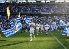 Mikel Merino salta al terreno de juego por delante de Zubeldia mientras corresponde con un aplauso las arengas del público realista.