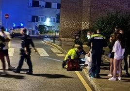 Los sanitarios atienden a la víctima sobre la acera.