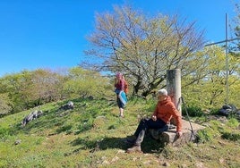 El donostiarra Javier y Mila posan junto al buzón geodésico de Otsabio.