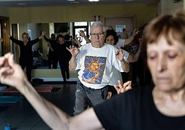 Jubilados practican yoga en el Hogar del Jubilado de Amara en Donostia.