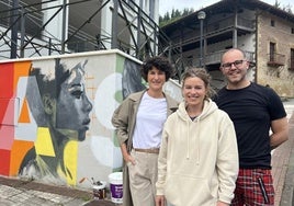 Nerea Arregi, Udane Juaristi y Jesús Santurde junto al mural que estos días cobra fuerza en Aizkorri Kalea.