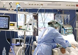 Una sanitaria atiende a un paciente Covid durante la pandemia.