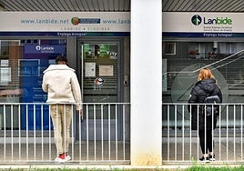 Un par de personas esperan frente a la sede de Lanbide