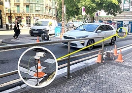 Un vehículo cruza el umbral del medidor de emisiones, que se encuentra protegido por varios conos en las dos aceras y está conectado a una cámara situada unos metros antes, tal como se aprecia en el círculo.