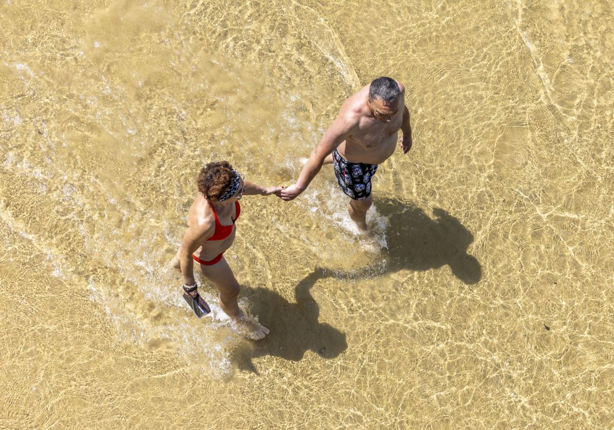 Una pareja paseando por la playa de La Concha.