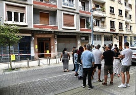 Vecinos esperan a la puerta del edificio incendiado.