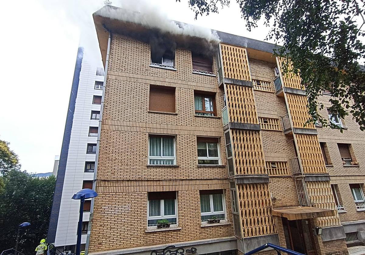 El humo sale de la vivienda del cuarto piso del portal 10 de la calle Sorgintzulo, don de se ha originado el incendio.