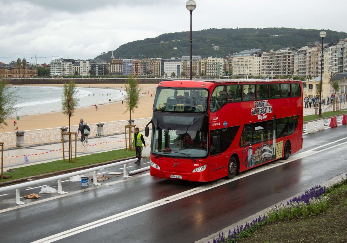 Un autobús turístico de Donosti City Tour junto a la playa de la Concha.