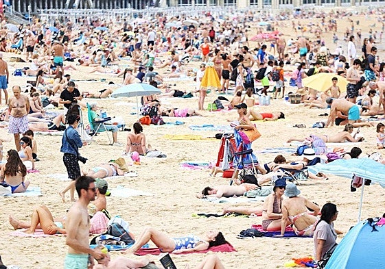 Decenas de personas disfrutan de un día de playa este verano en San Sebastián.