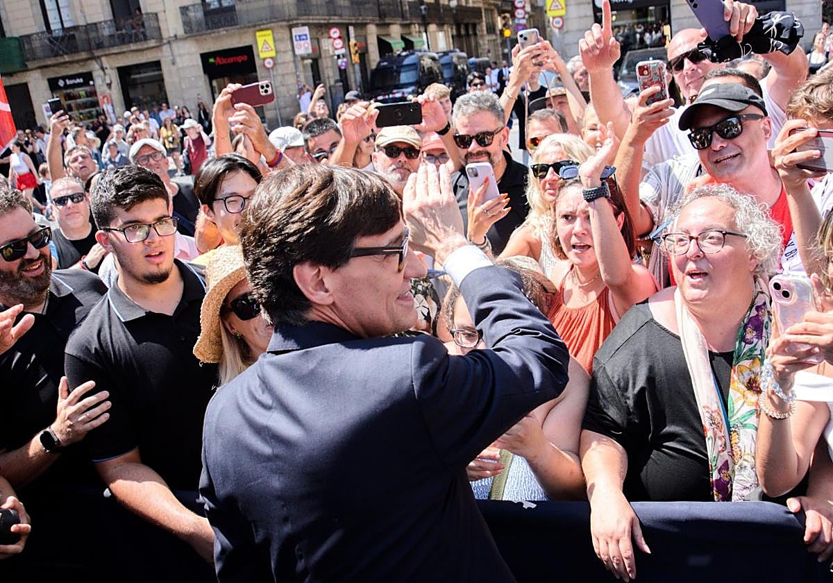 El president Illa recibe las felicitaciones del público que le esperaba el sábado en la playa de Sant Jaume tras su toma de posesión.
