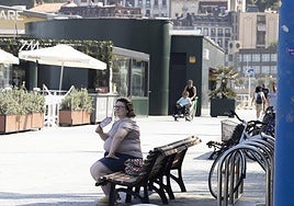 Una mujer se abanica en la zona de la Zurriola, en el barrio donostiarra de Gros.