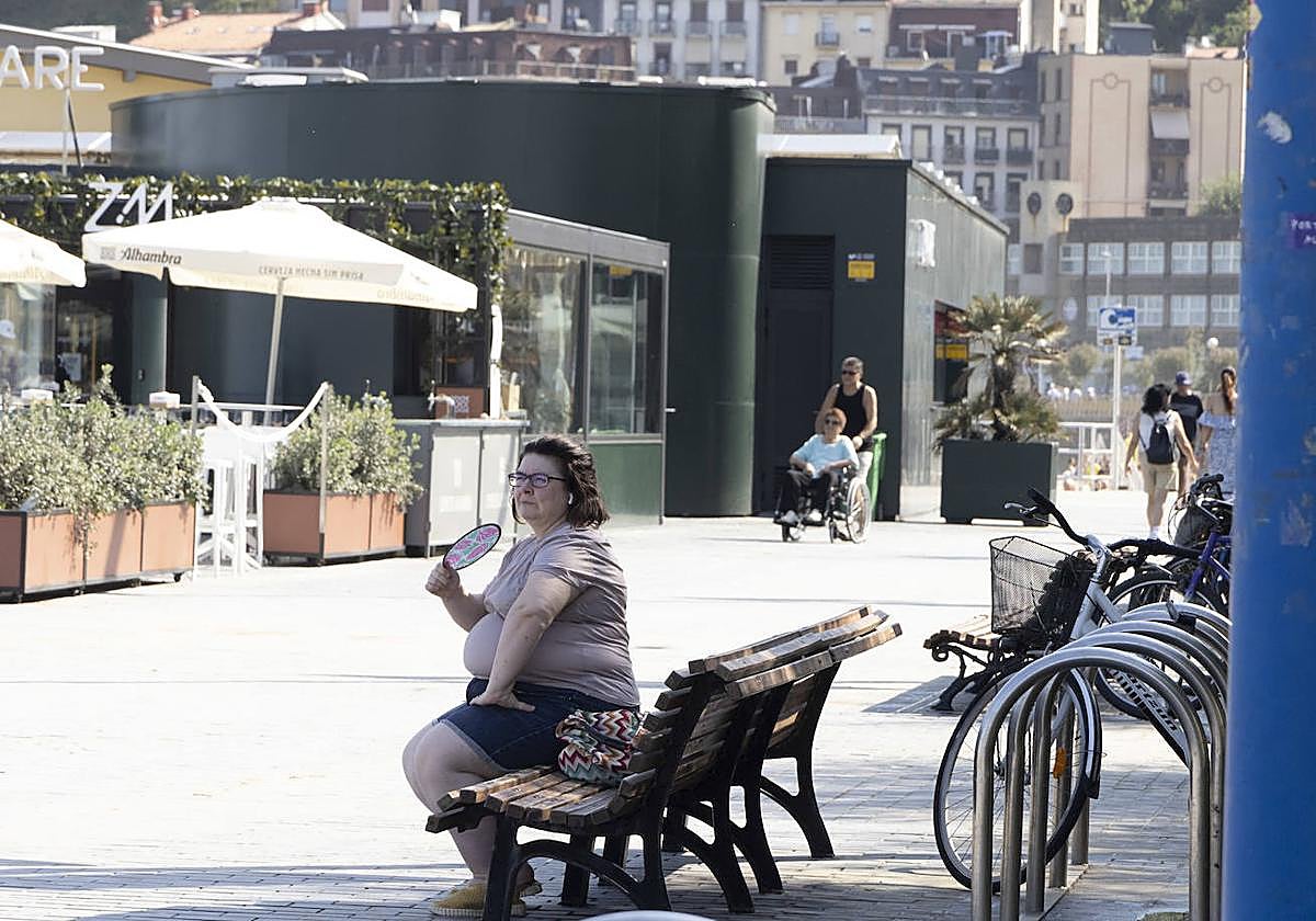 Una mujer se abanica en la zona de la Zurriola, en el barrio donostiarra de Gros.