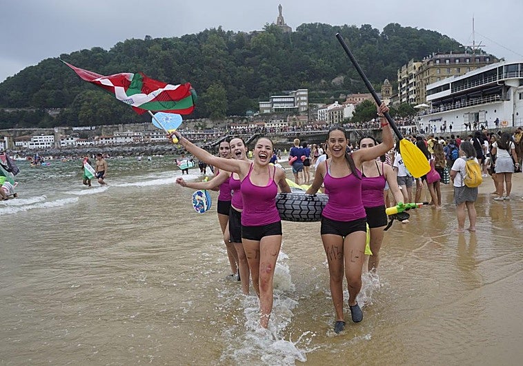 Un grupo de jóvenes celebran haber llegado a la playa.